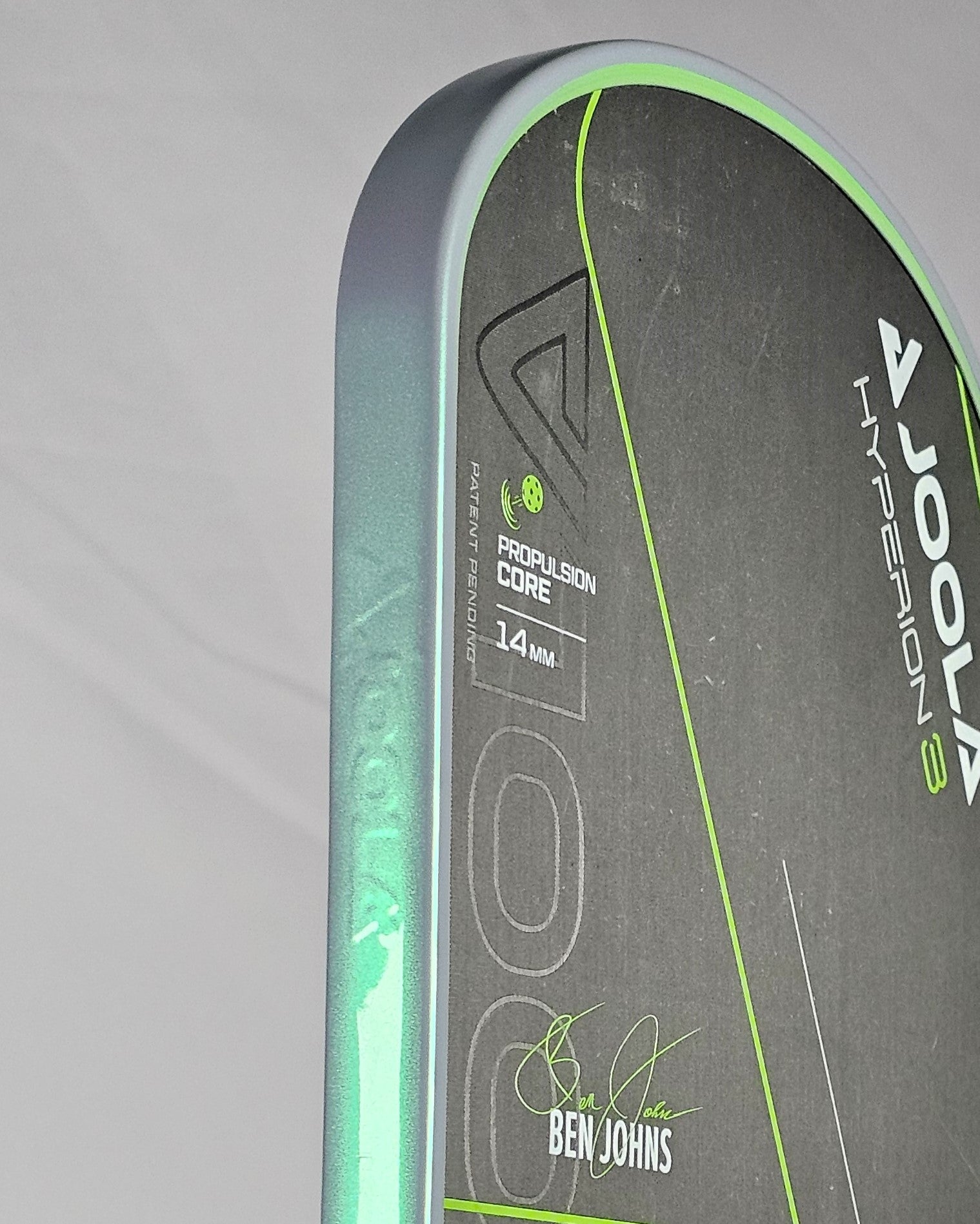 Close-up of a Joola Hyperion pickleball paddle with grey/green edge tape
