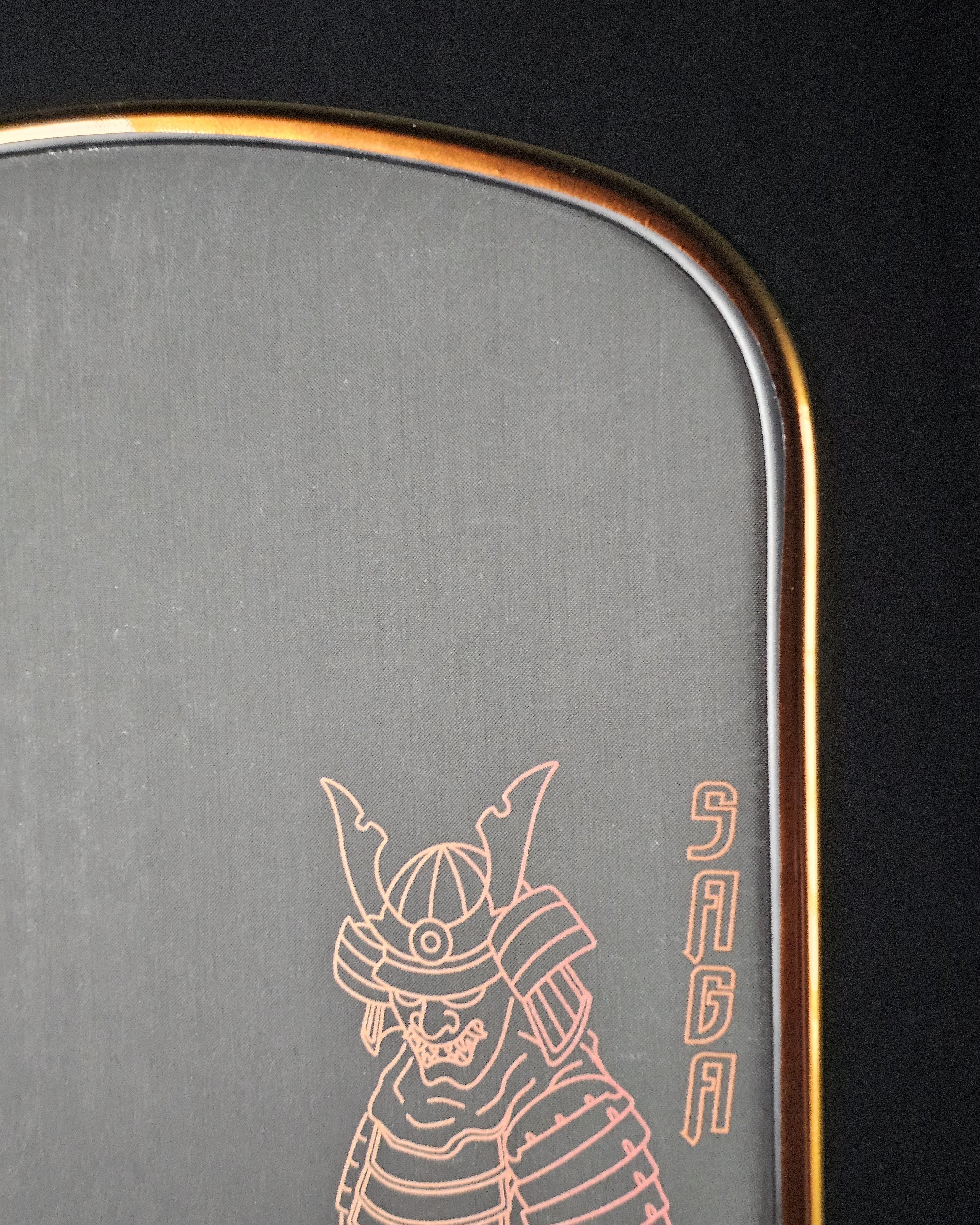 Close-up of a pickleball paddle with Bronze color shift edge tape showing clean wrap around corner