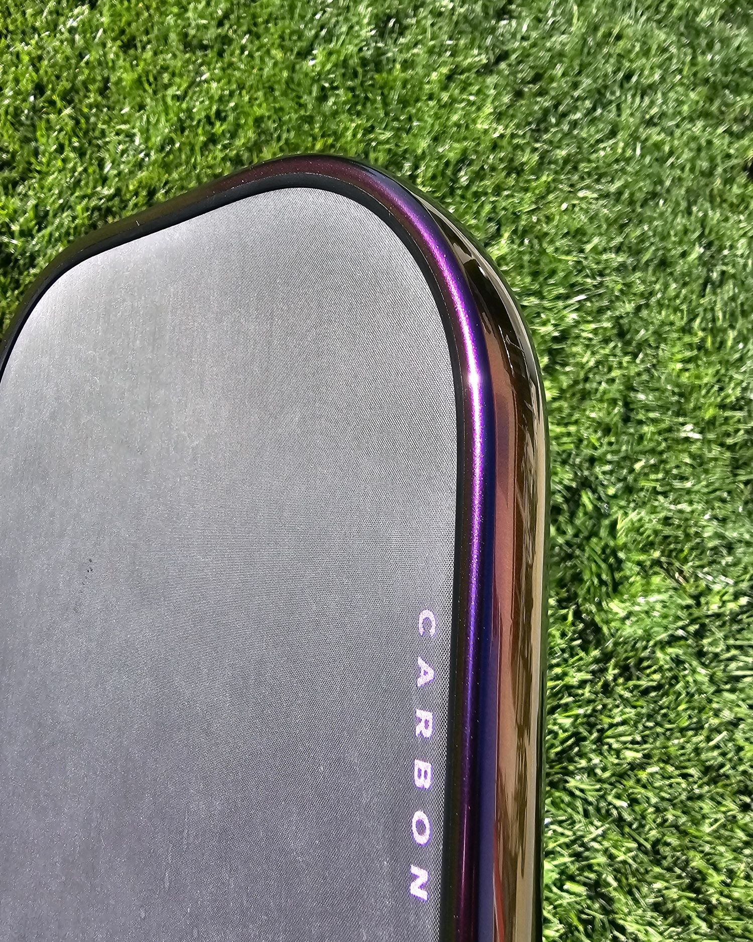 Close-up of a pickleball paddle with Indigo Sunset color shift edge tape