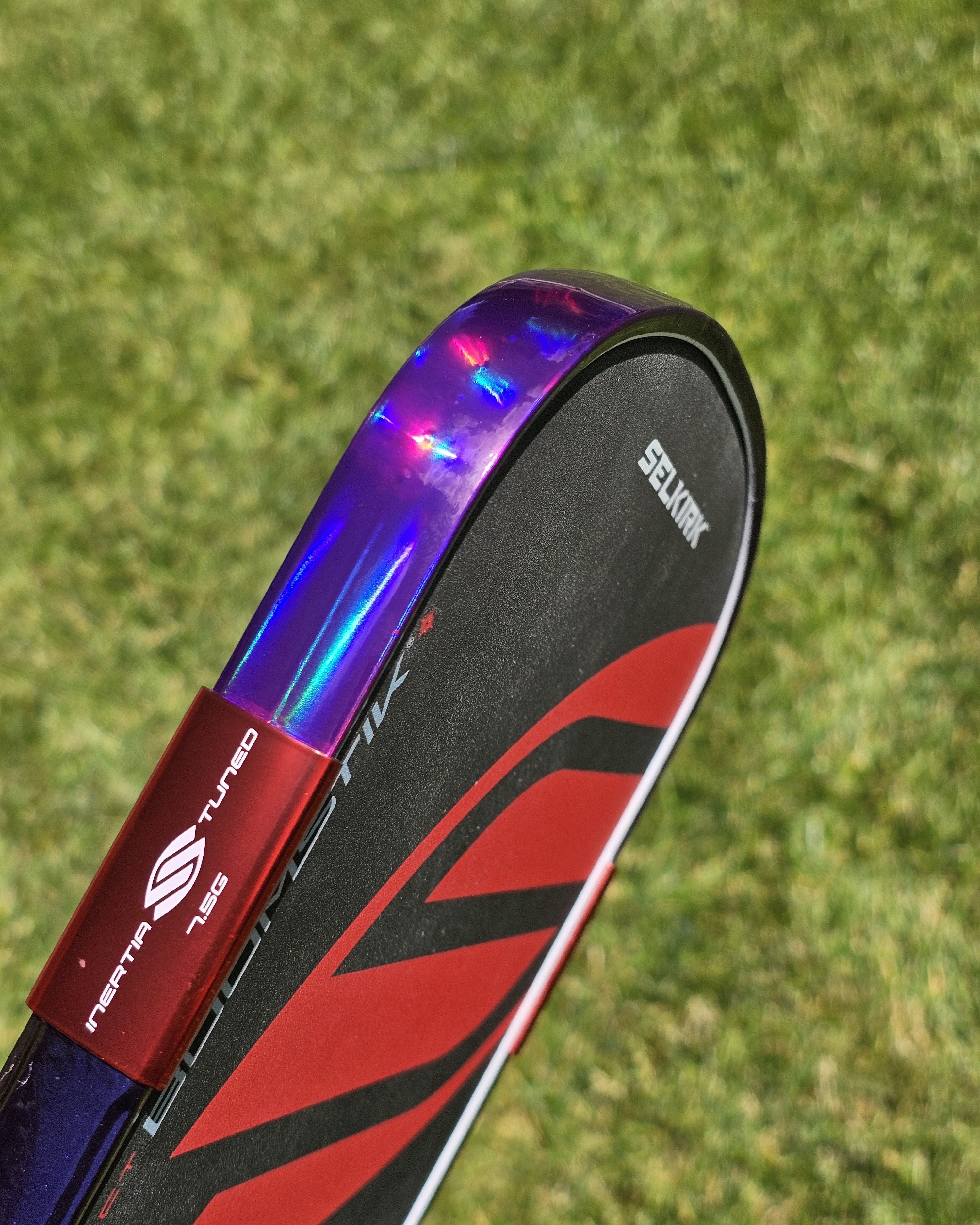 close-up of a pickleball paddle with holographic purple edge tape