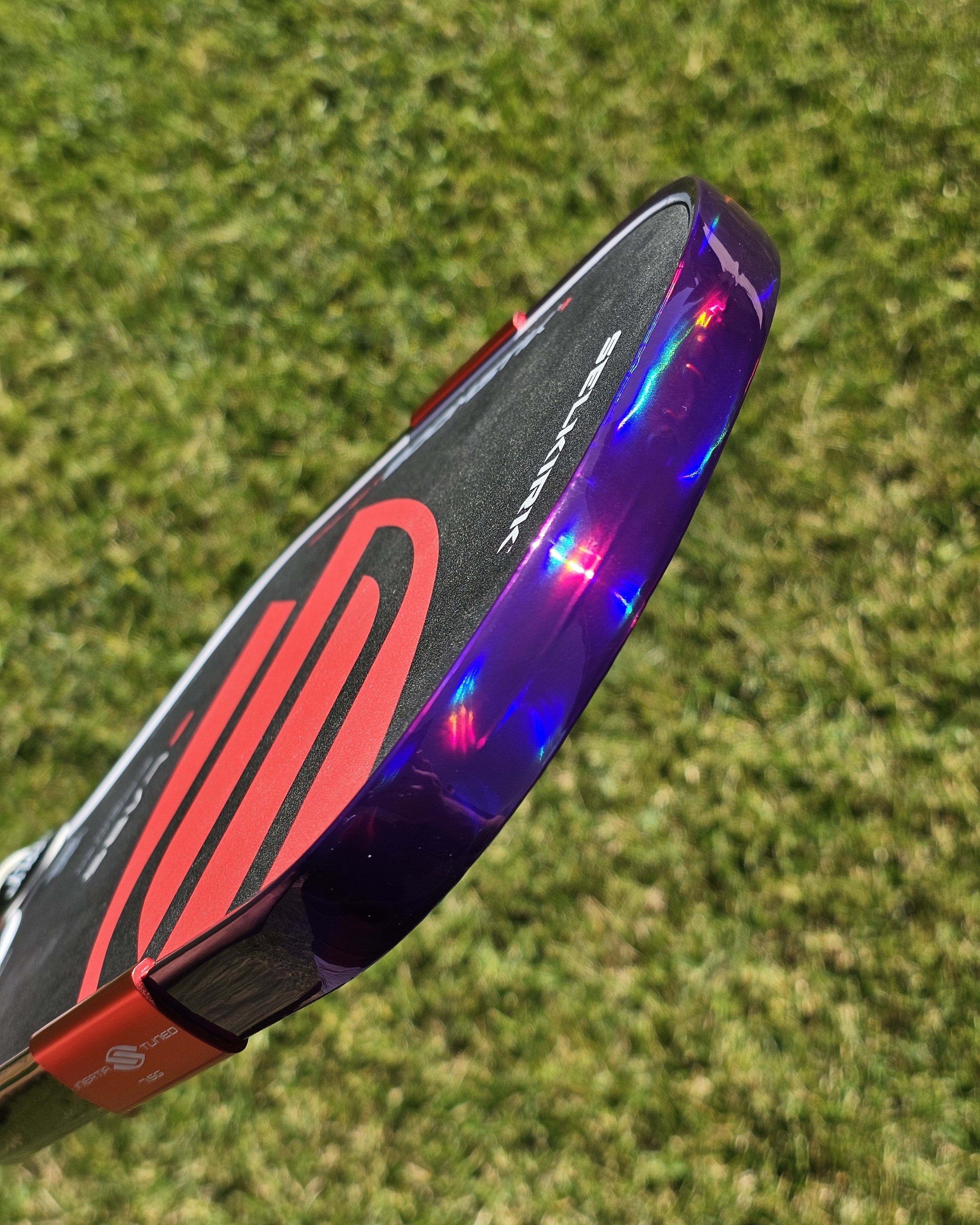 close-up of a picklball paddle with holographic purple edge tape