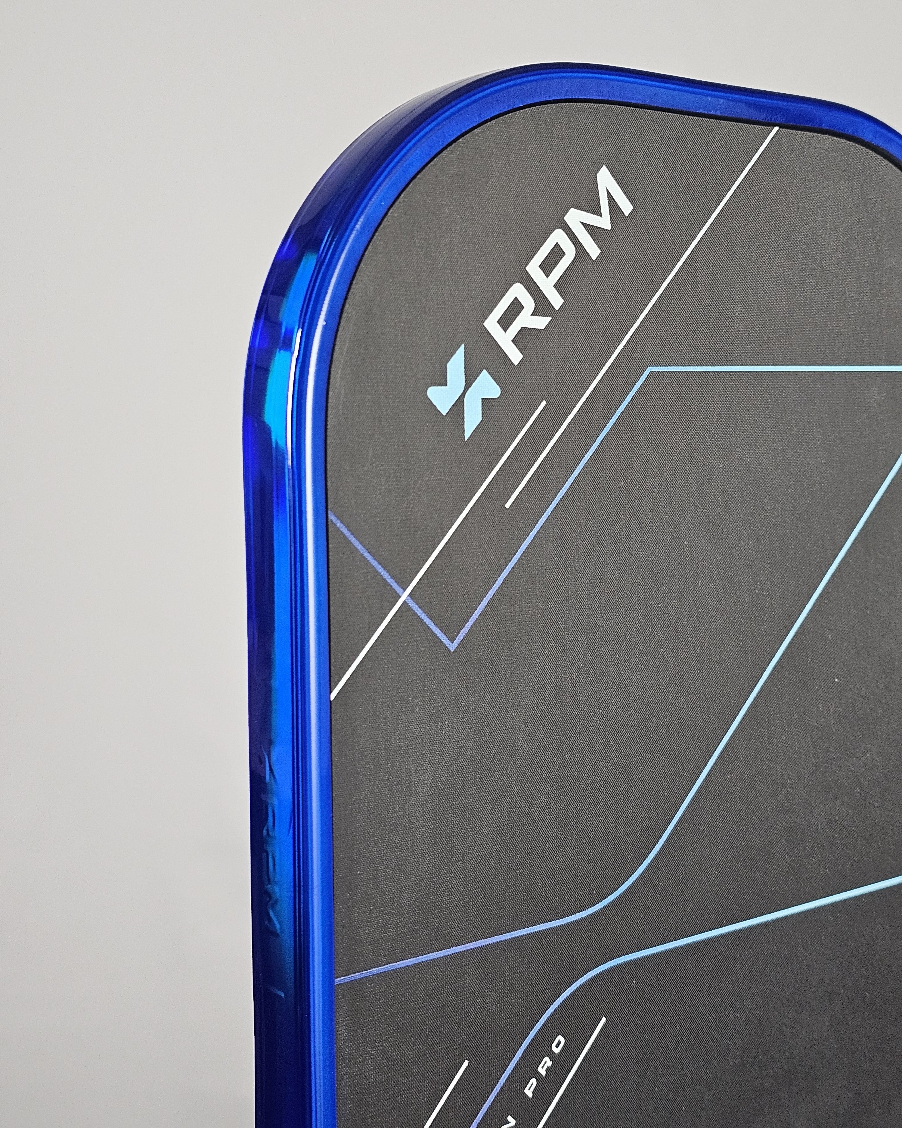 Close-up of RPM pickleball paddle with blue hologram edge tape