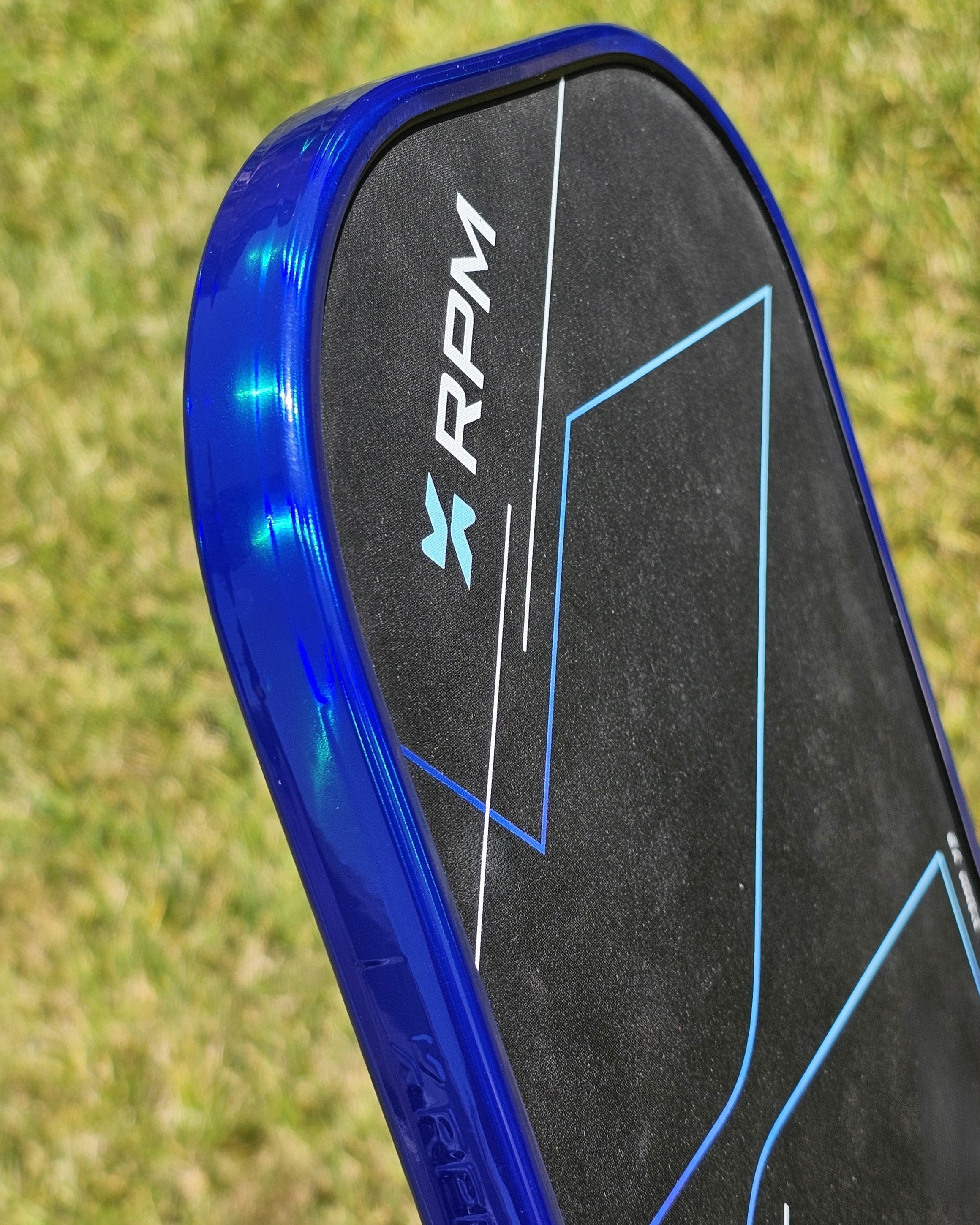 Close-up of RPM Pickleball paddle with blue hologram edge tape