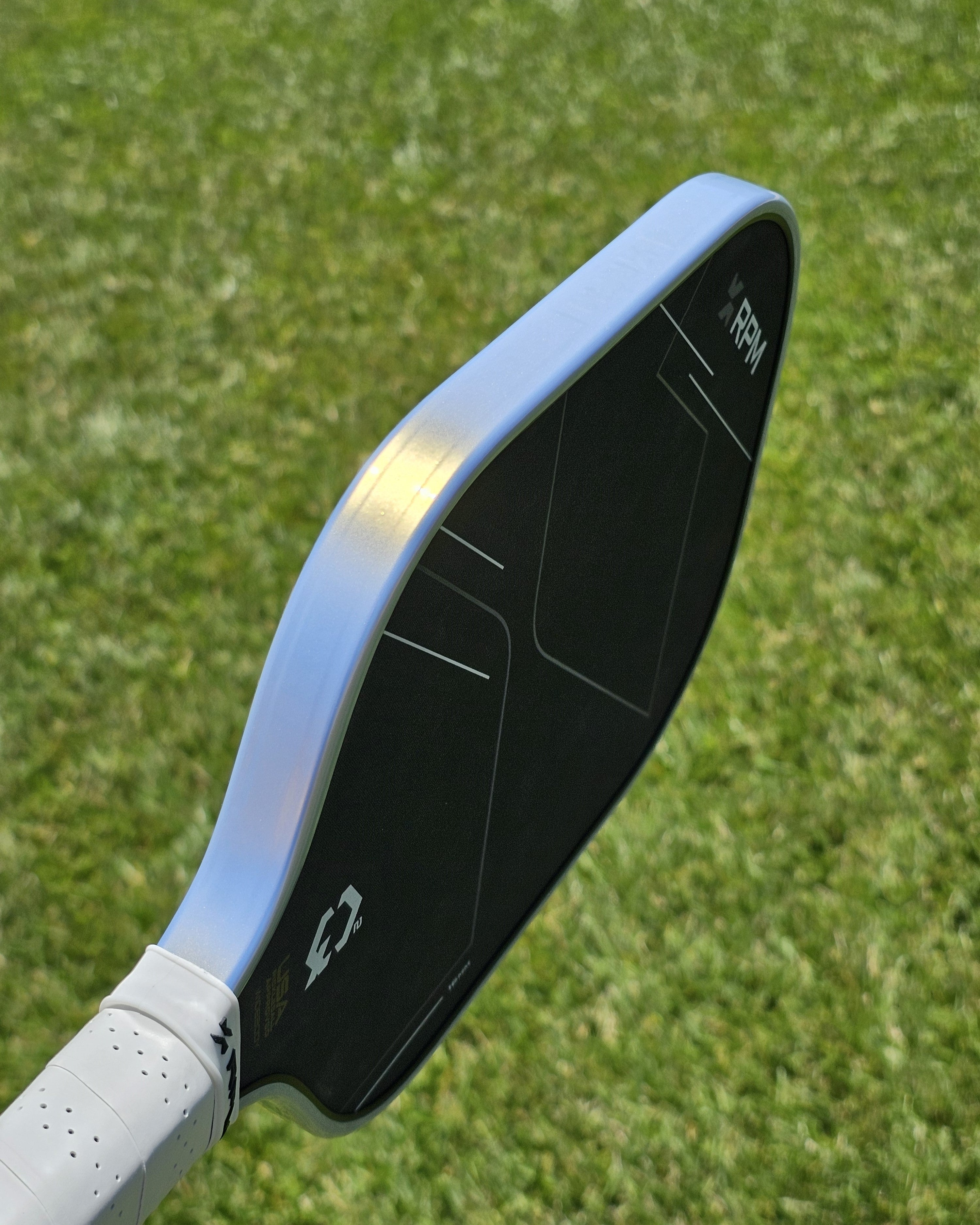 Edge view of a RPM pickleball paddle showing the installed platinum and gold edge guard protective tape