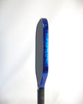 A side view of a pickleball paddle with a Blue Damascus edge tape installed shown against a white background
