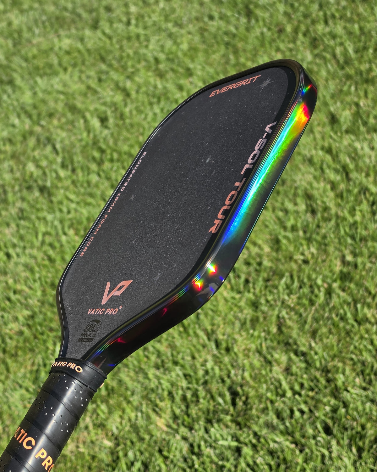 A close-up of a Vatic Pro VSol Tour paddle withd a holographic rainbow from the Smoke Hologram edge tape