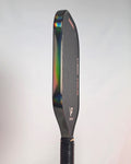 A close-up side view of a pickleball paddle showing its Smoke Hologram Edge Tape with, a holographic rainbow effect.