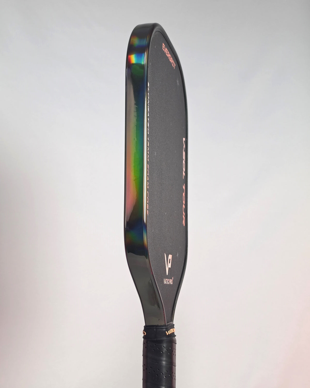 A close-up side view of a pickleball paddle showing its Smoke Hologram Edge Tape with, a holographic rainbow effect.