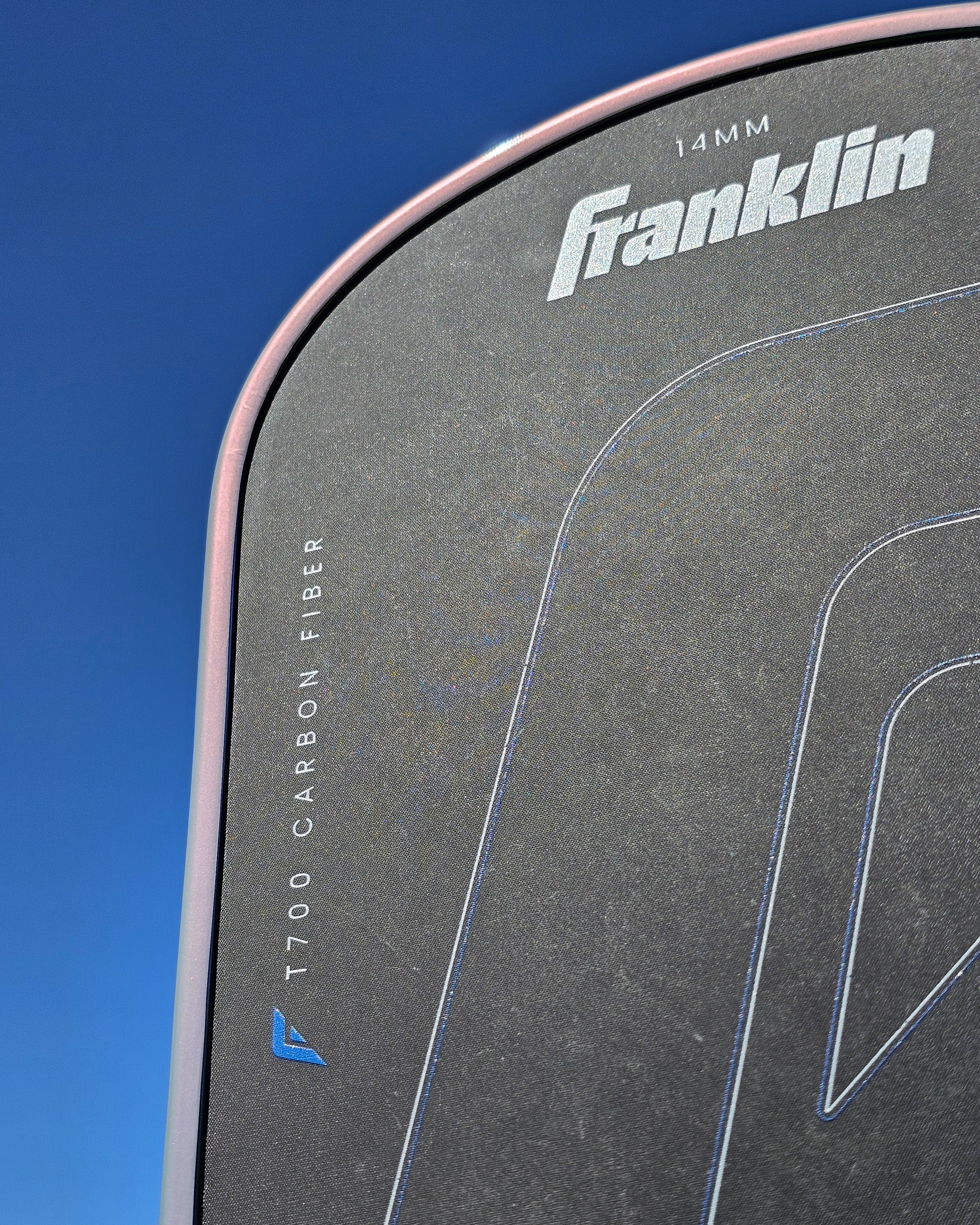 Close-up of Franklin C45 pickleball paddle with grey/pink edge tape.