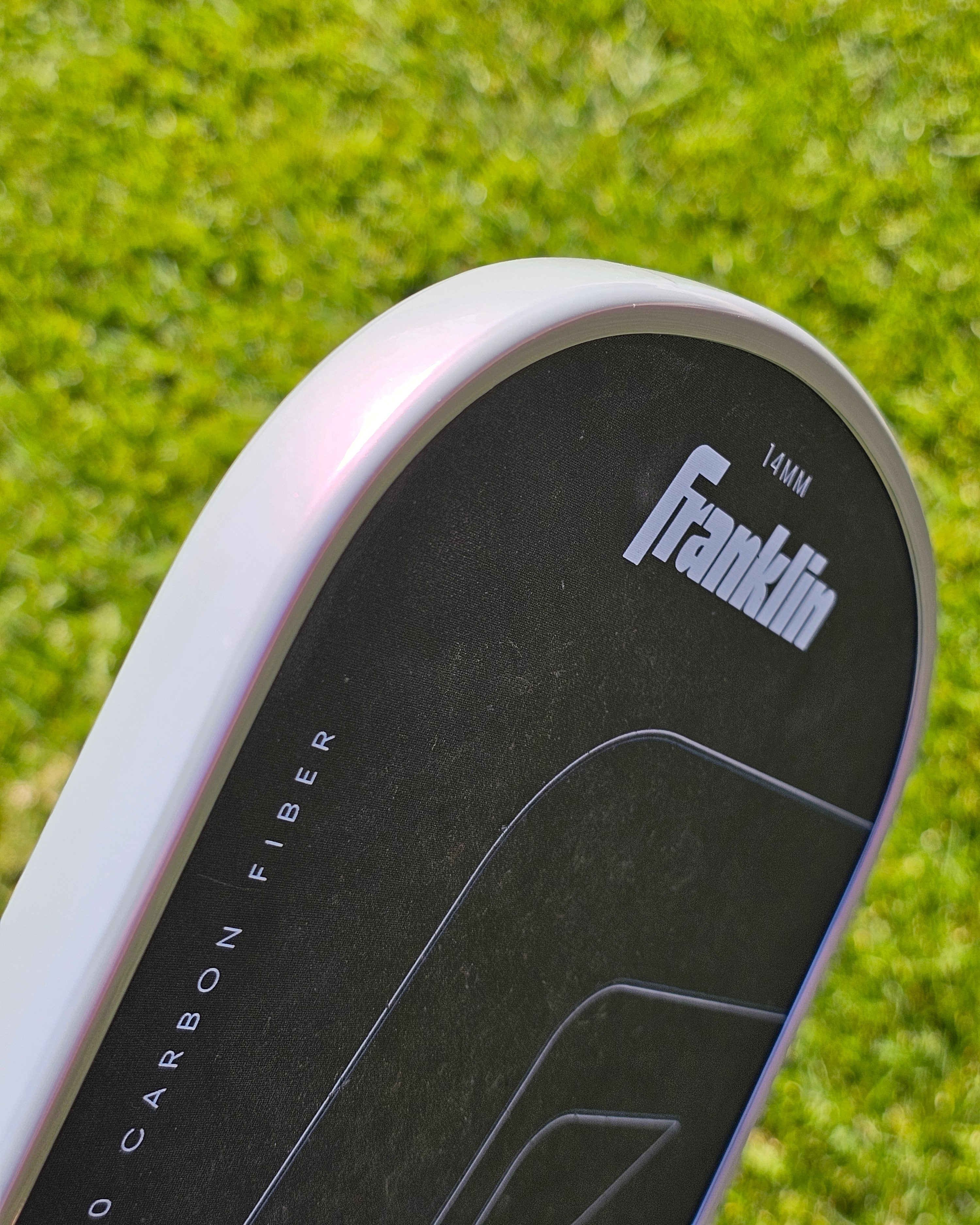 Close-up of a FranklinC45 pickleball paddle with grey/pink edge tape